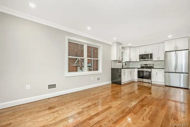 a living room with furniture and kitchen view
