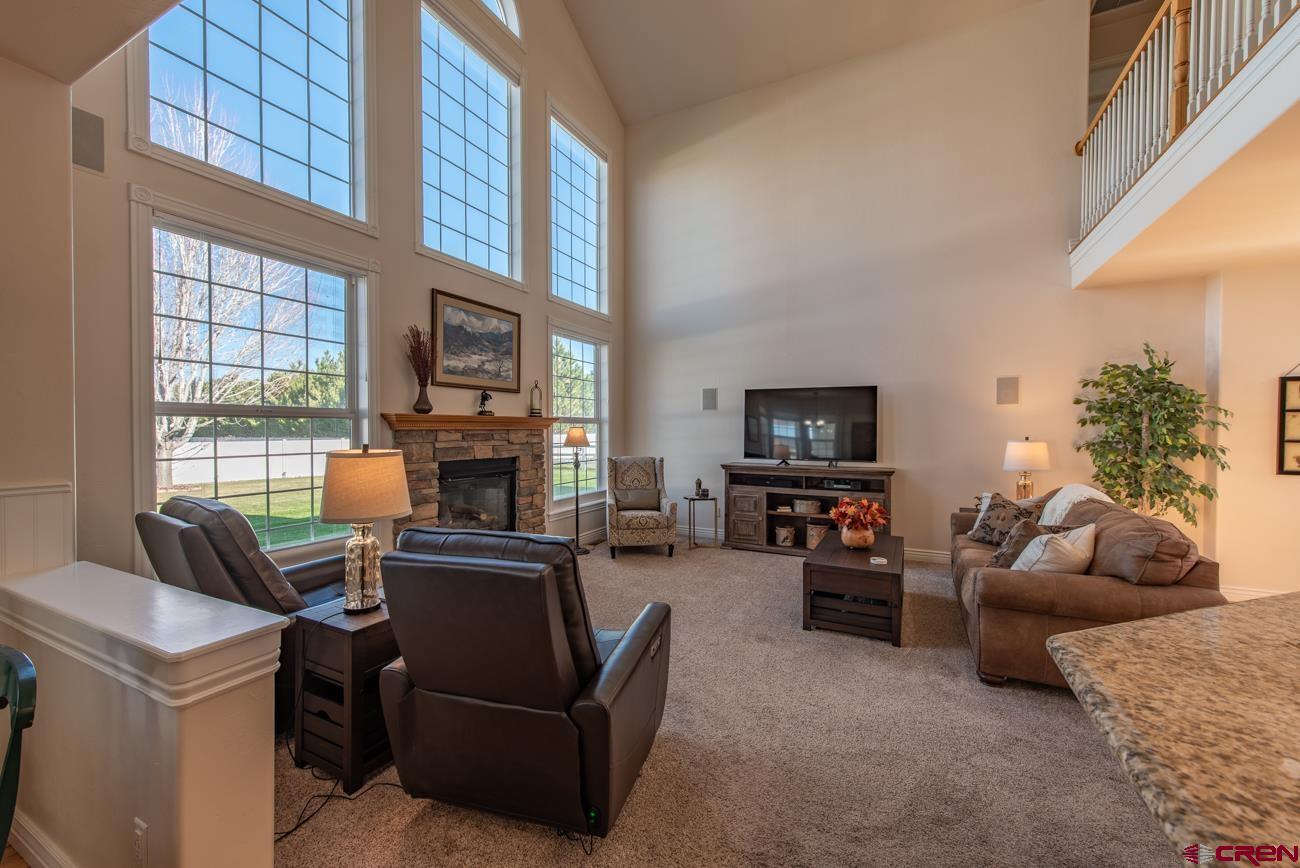 68020 Tumbleweed Road Montrose, CO 81403 - Photo 12 of 45 a living room with furniture a flat screen tv and a fireplace