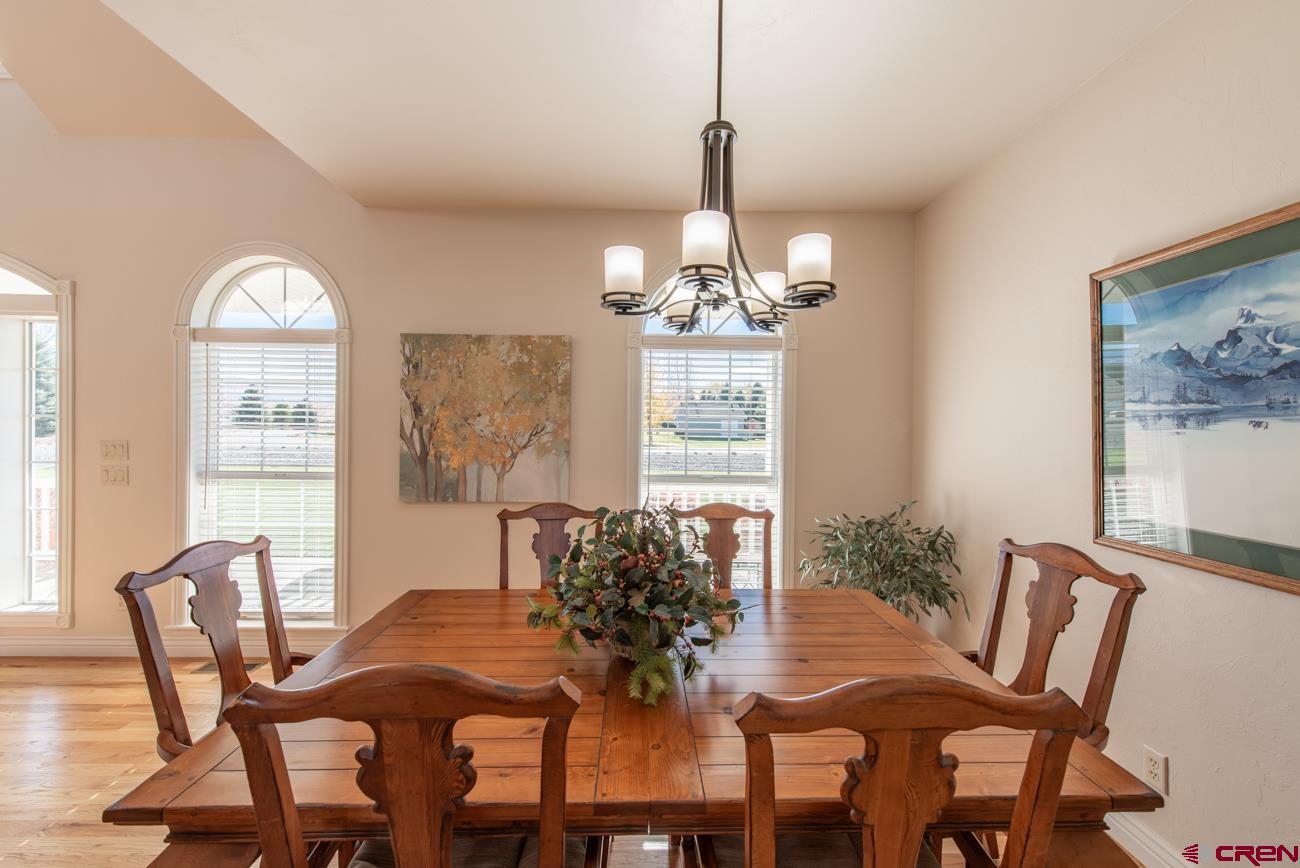 68020 Tumbleweed Road Montrose, CO 81403 - Photo 25 of 45 a view of a dining room with furniture a chandelier and wooden floor