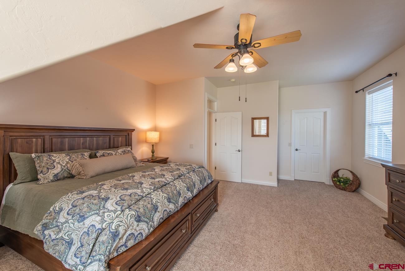 68020 Tumbleweed Road Montrose, CO 81403 - Photo 38 of 45 a bedroom with a bed and a chandelier