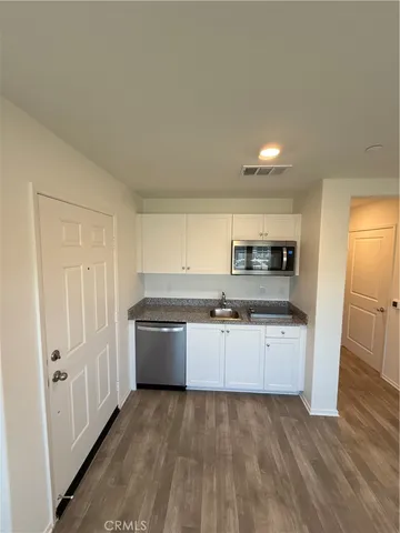 a large kitchen with stainless steel appliances granite countertop a refrigerator and a stove top oven