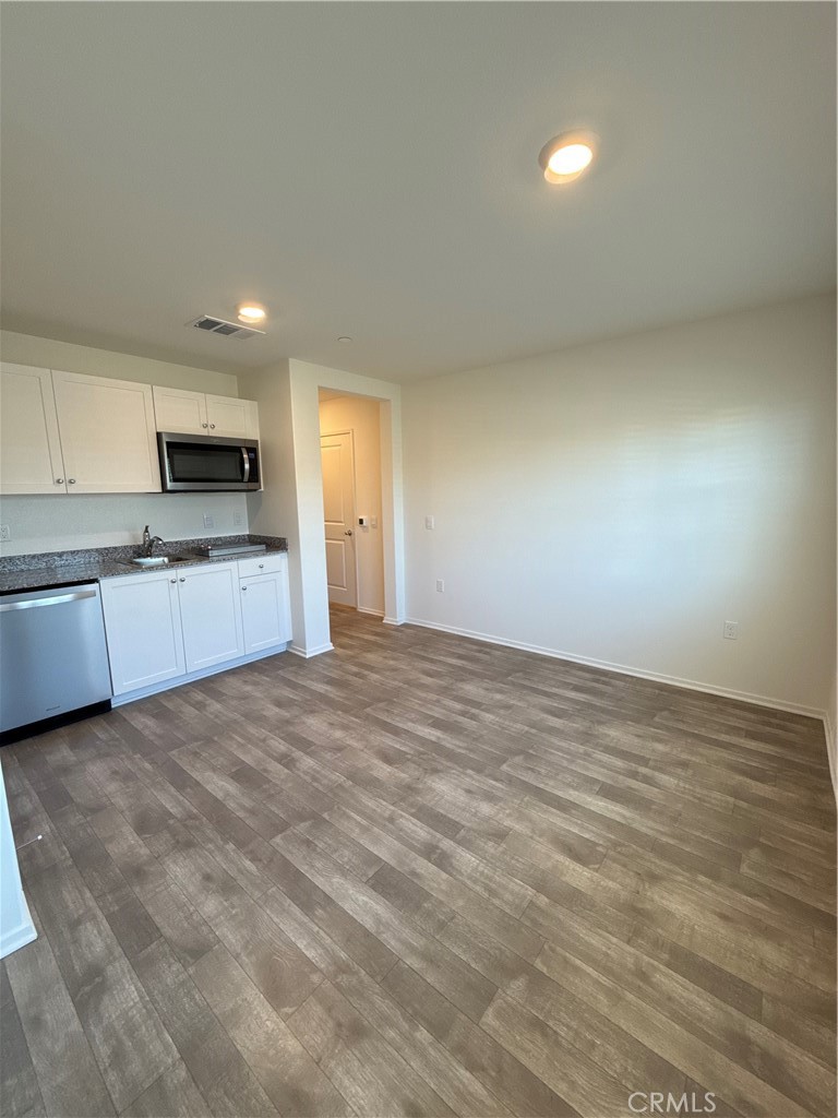 479 Hollyhock Circle San Jacinto, CA 92582 - Photo 28 of 36 a view of an empty room and kitchen with microwave
