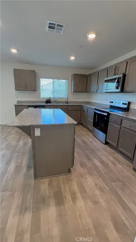 a large kitchen with stainless steel appliances kitchen island a large counter top and a stove