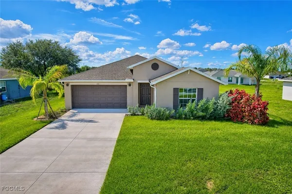 a front view of a house with a garden and yard