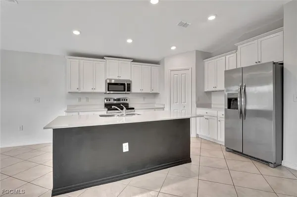 a kitchen with stainless steel appliances granite countertop a refrigerator sink and stove