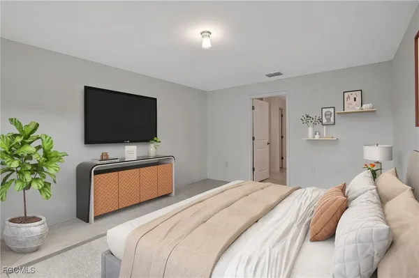 a bedroom with a bed and a flat screen tv