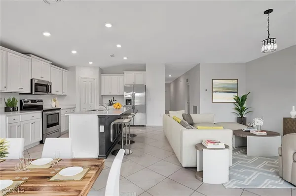 a living room with furniture a dining table and kitchen view