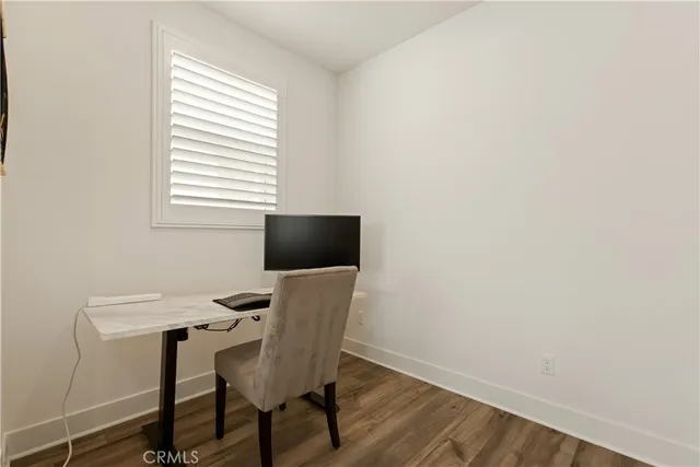 a view of a workspace with furniture and a window