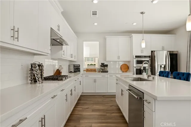a kitchen with stainless steel appliances a sink stove refrigerator and cabinets
