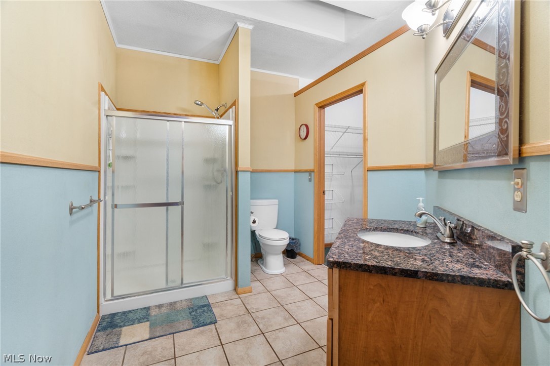 1640 Old Delaware Road Mount Vernon, OH 43050 - Photo 21 of 49 Bathroom featuring a stall shower, vanity, light tile patterned floors, and crown molding