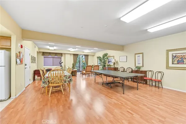 a dining room with furniture wooden floor a rug and a painting