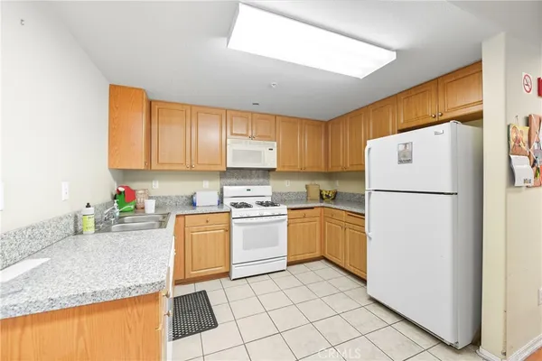 a kitchen with a sink a refrigerator and a stove top oven