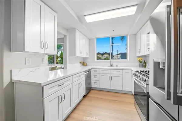 a kitchen with white cabinets sink and white appliances