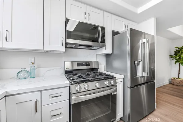 a kitchen with stainless steel appliances granite countertop a refrigerator stove and microwave