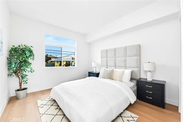 a bedroom with a bed and a potted plant