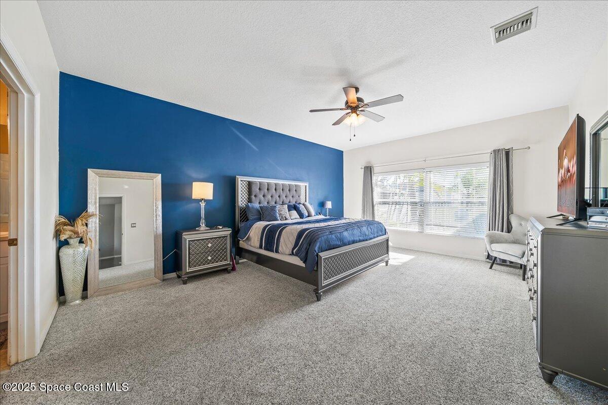 7469 Hackberry Road Cocoa, FL 32927 - Photo 13 of 27 a spacious bedroom with a bed and a flat screen tv