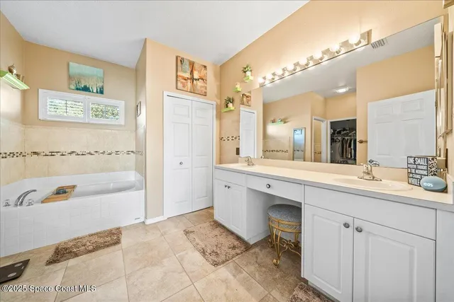 a spacious bathroom with a tub a sink and mirror