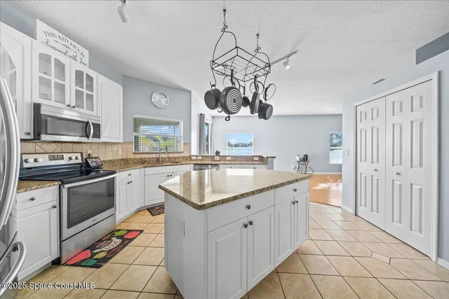 a kitchen with stainless steel appliances granite countertop a sink dishwasher stove and refrigerator with wooden floor