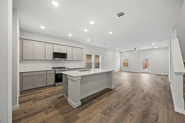 a large kitchen with stainless steel appliances granite countertop a stove and a sink