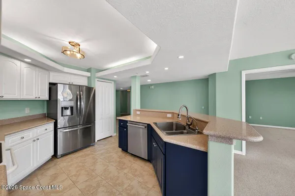 a kitchen with white cabinets and white appliances