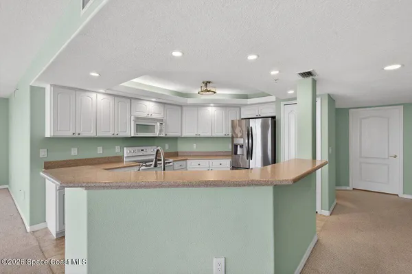 a kitchen with white cabinets and white appliances