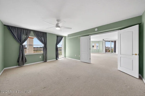 a view of a livingroom with a ceiling fan and window