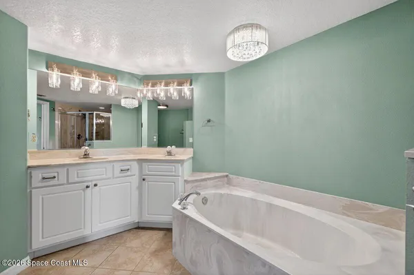 a bathroom with a granite countertop sink mirror and bathtub