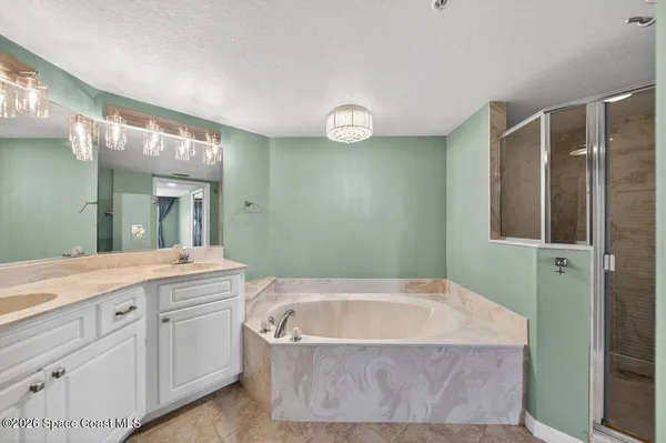 a bathroom with a granite countertop bathtub sink vanity and mirror