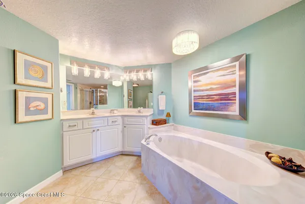 a bathroom with a tub a sink and a mirror