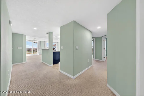 a view of a big room with kitchen and windows