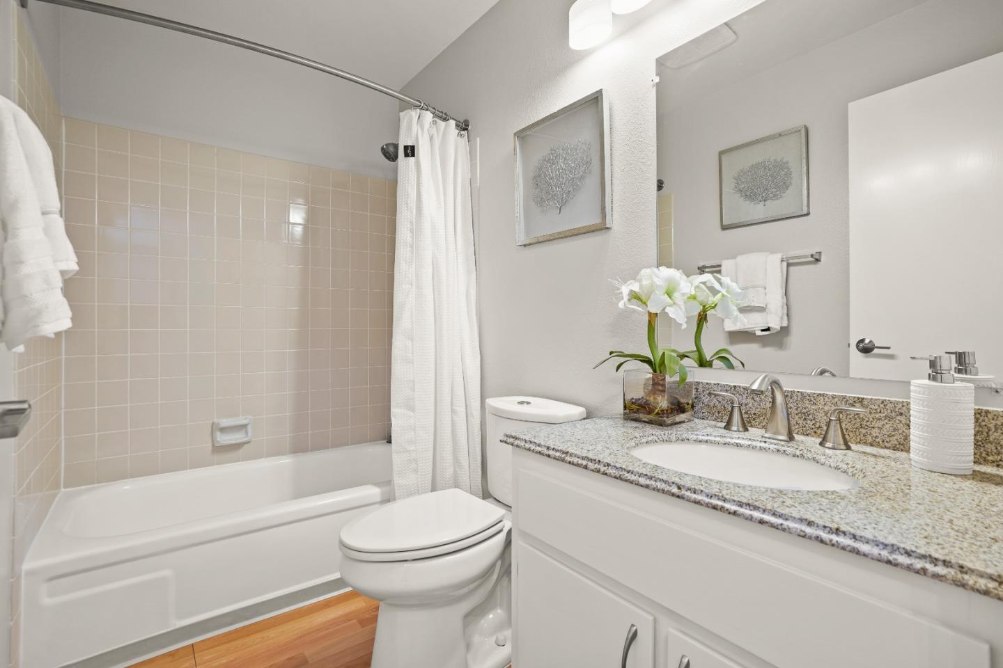 928 Wright Avenue, Unit 1005 Mountain View, CA 94043 - Photo 18 of 25 a bathroom with a granite countertop sink a toilet and shower