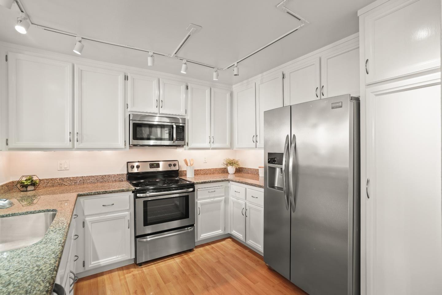 928 Wright Avenue, Unit 1005 Mountain View, CA 94043 - Photo 8 of 25 a kitchen with stainless steel appliances granite countertop a refrigerator stove and sink
