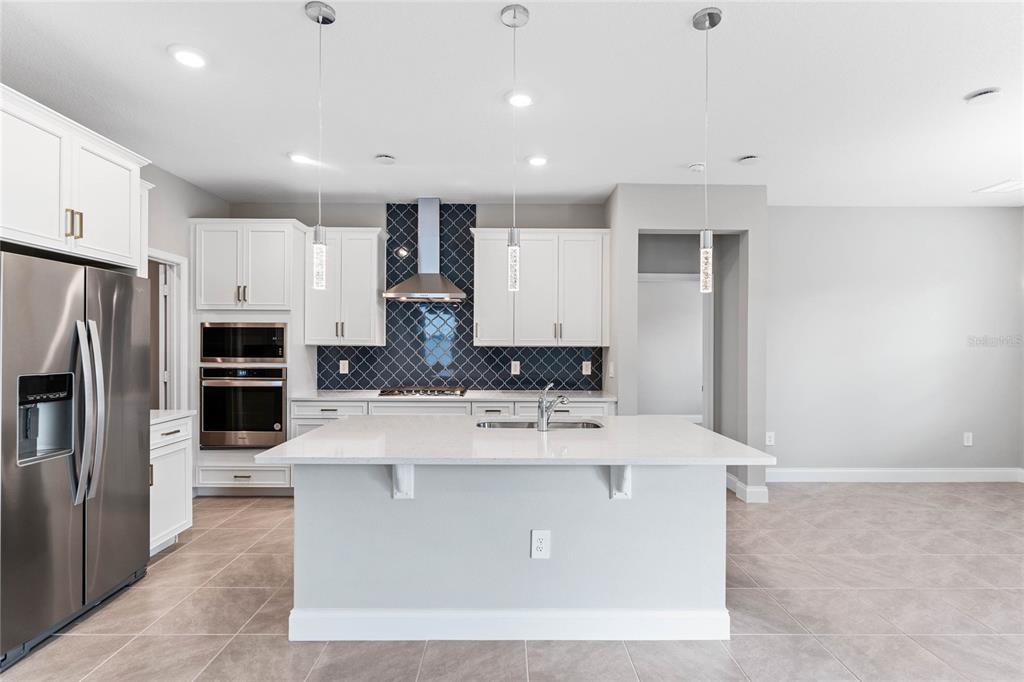 851 Vineyard Rdg Road Minneola, FL 34715 - Photo 4 of 13 a view of kitchen with stainless steel appliances kitchen island a stove a refrigerator a oven and white cabinets