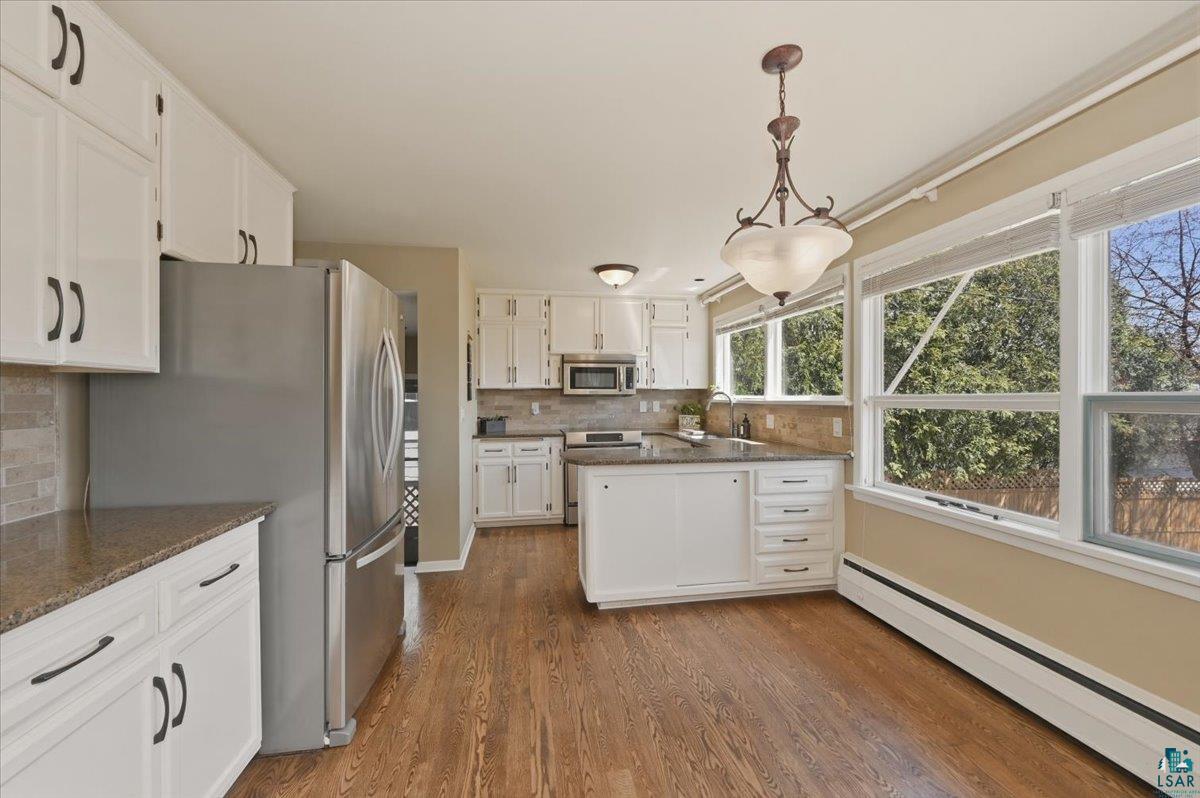 1918 West Kent Road Duluth, MN 55812 - Photo 5 of 42 Kitchen featuring white cabinetry, stainless steel appliances, and wood-finish flooring