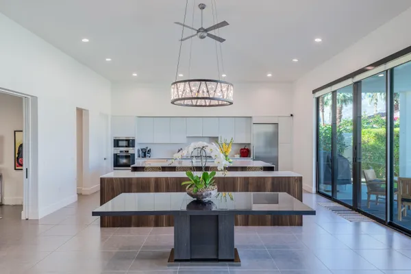 a living room with stainless steel appliances granite countertop furniture and a chandelier