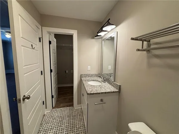 a bathroom with a granite countertop sink toilet and shower