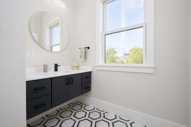 a spacious bathroom with a sink mirror and a window