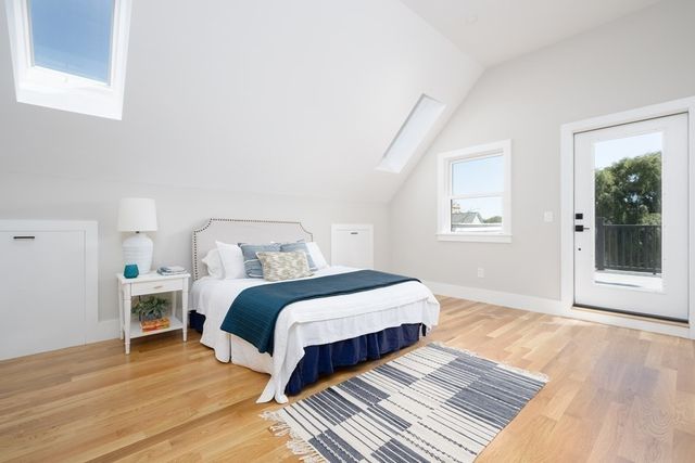 a spacious bedroom with a bed and wooden floor