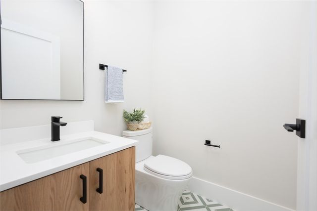 a bathroom with a sink a toilet and mirror