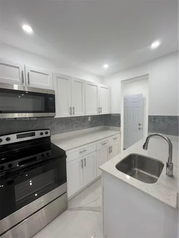 a kitchen with granite countertop a stove and a sink