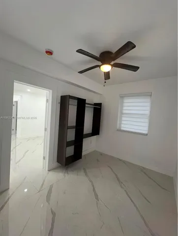 a view of an empty room with a ceiling fan