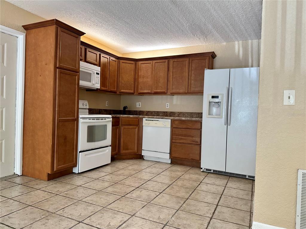 8205 Sun Spring Circle, Unit B1 Orlando, FL 32825 - Photo 2 of 14 a kitchen with stainless steel appliances granite countertop a refrigerator and a stove top oven