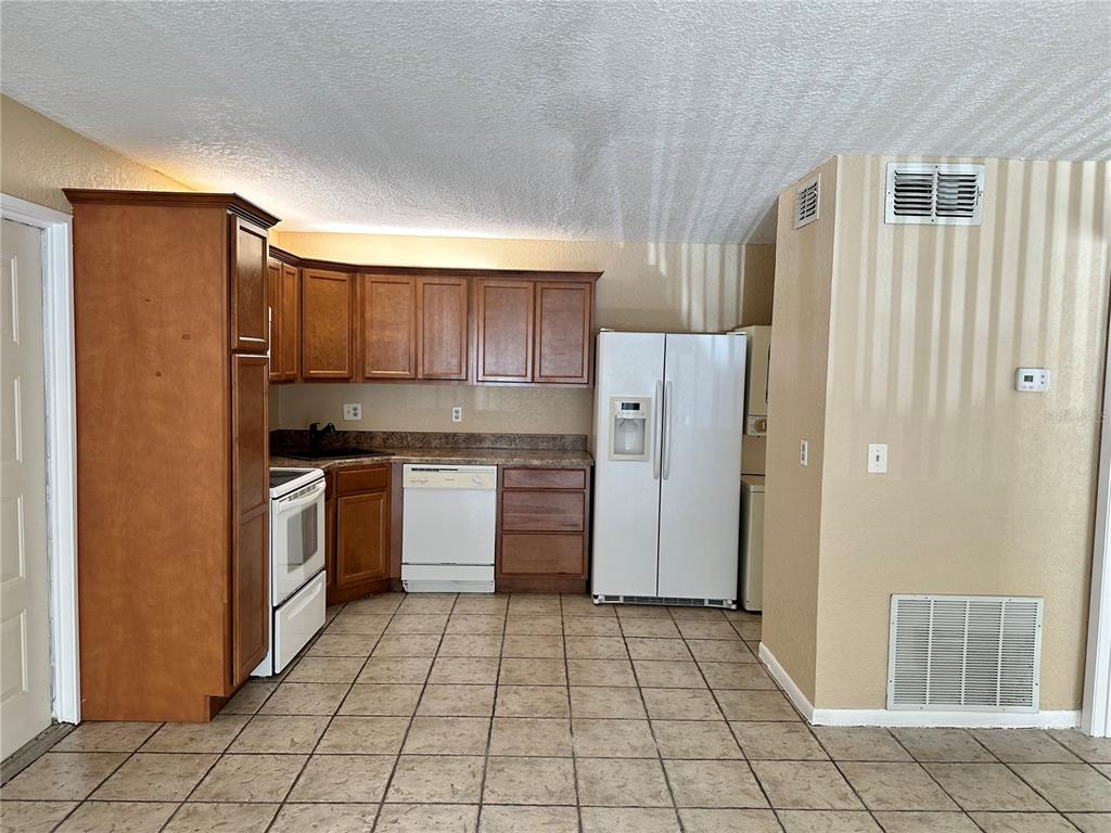 8205 Sun Spring Circle, Unit B1 Orlando, FL 32825 - Photo 3 of 14 a kitchen with a refrigerator a stove and cabinets