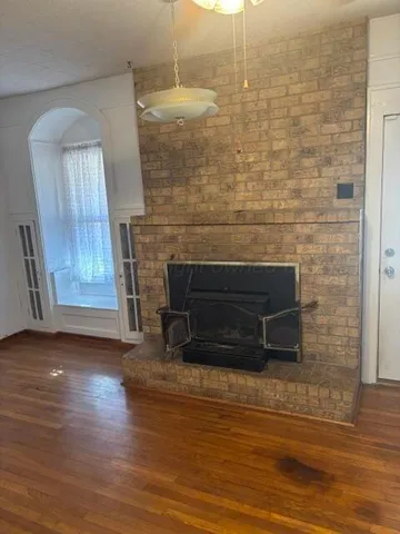 a view of a livingroom with wooden floor and a fireplace