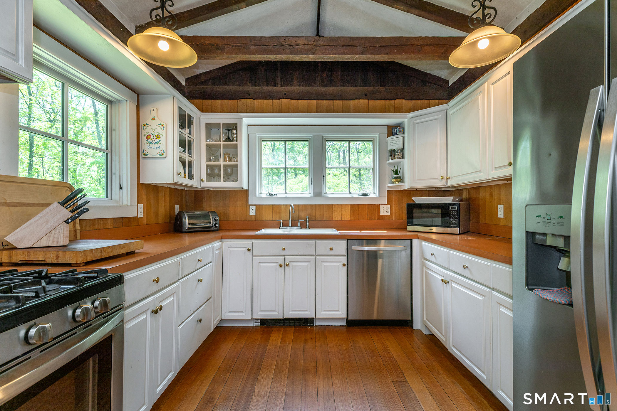 25 Bald Hill Road Kent, CT 06785 - Photo 8 of 38 Bursting with timeless charm, this sunlit kitchen features a spacious open layout under soaring ceilings. Wide honey wood floors add instant character, creating the perfect foundation for your modern updates and personal touch