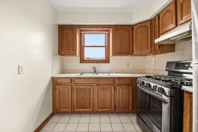a kitchen with a stove sink and cabinets