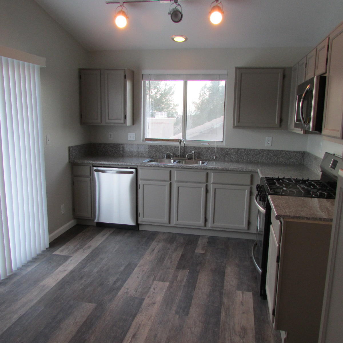 1832 Ivory Avenue Palmdale, CA 93550 - Photo 22 of 52 a kitchen with stainless steel appliances granite countertop wooden cabinets a stove a sink and a window