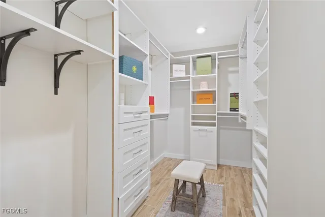 a view of walk in closet with clothes and shoes