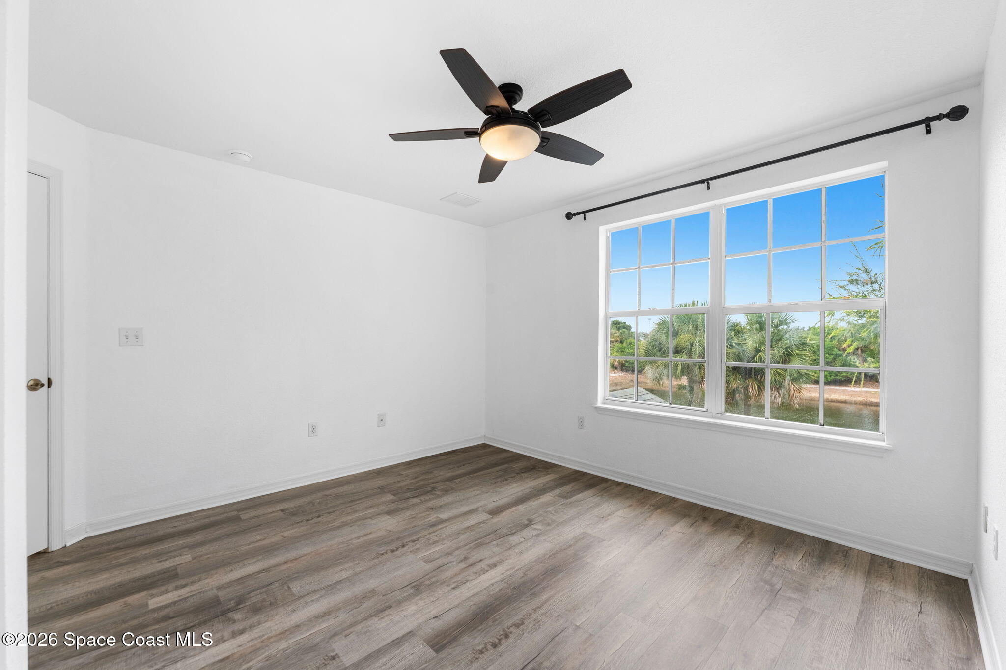 110 Turpial Way, Unit 106 Melbourne, FL 32901 - Photo 30 of 50 a view of an empty room with wooden floor and a window