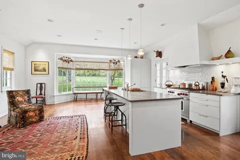 a open kitchen with stainless steel appliances granite countertop a stove refrigerator and a dining table with wooden floor